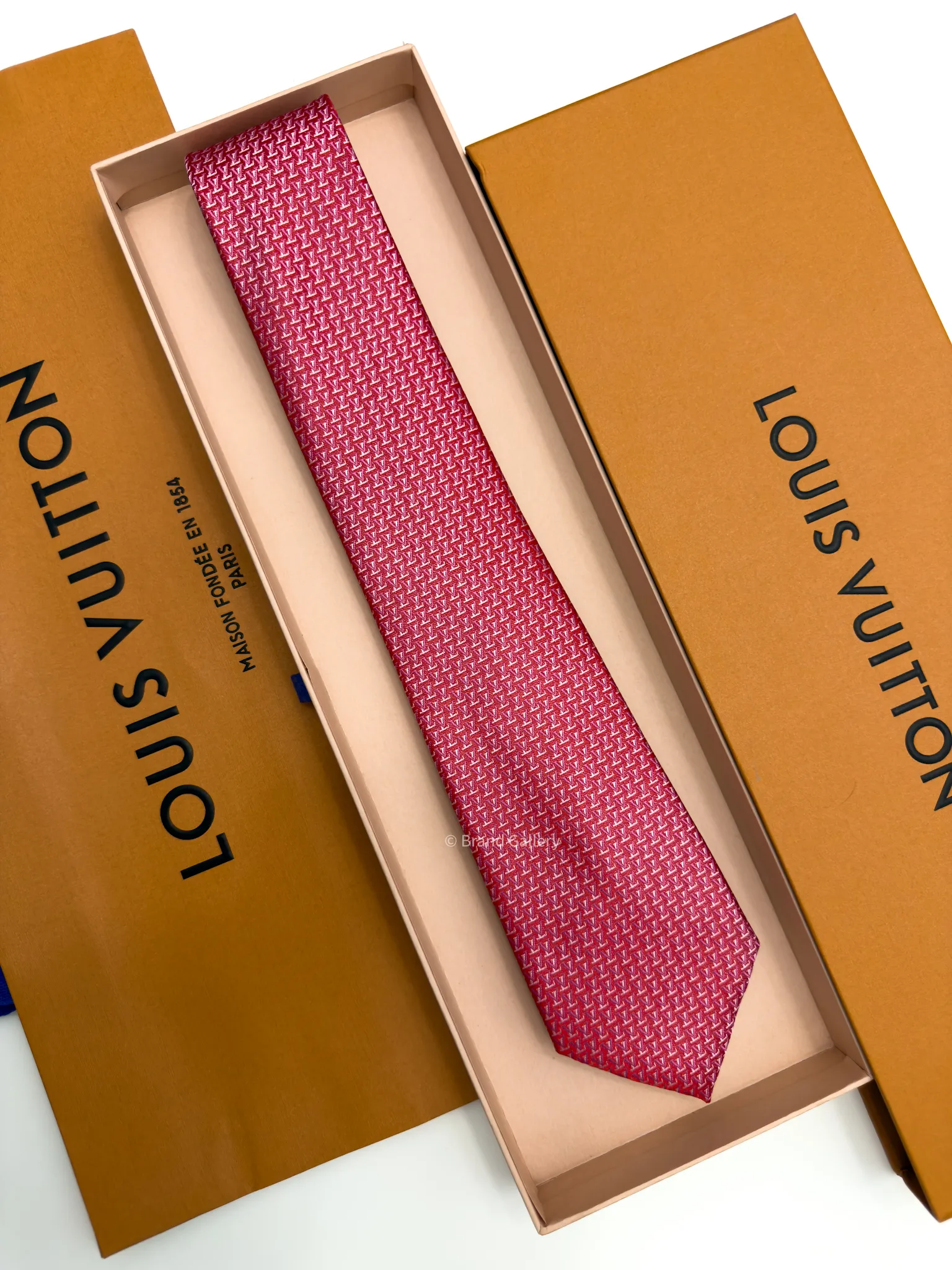 Raspberry red silk tie with repeating pink and white geometric pattern
