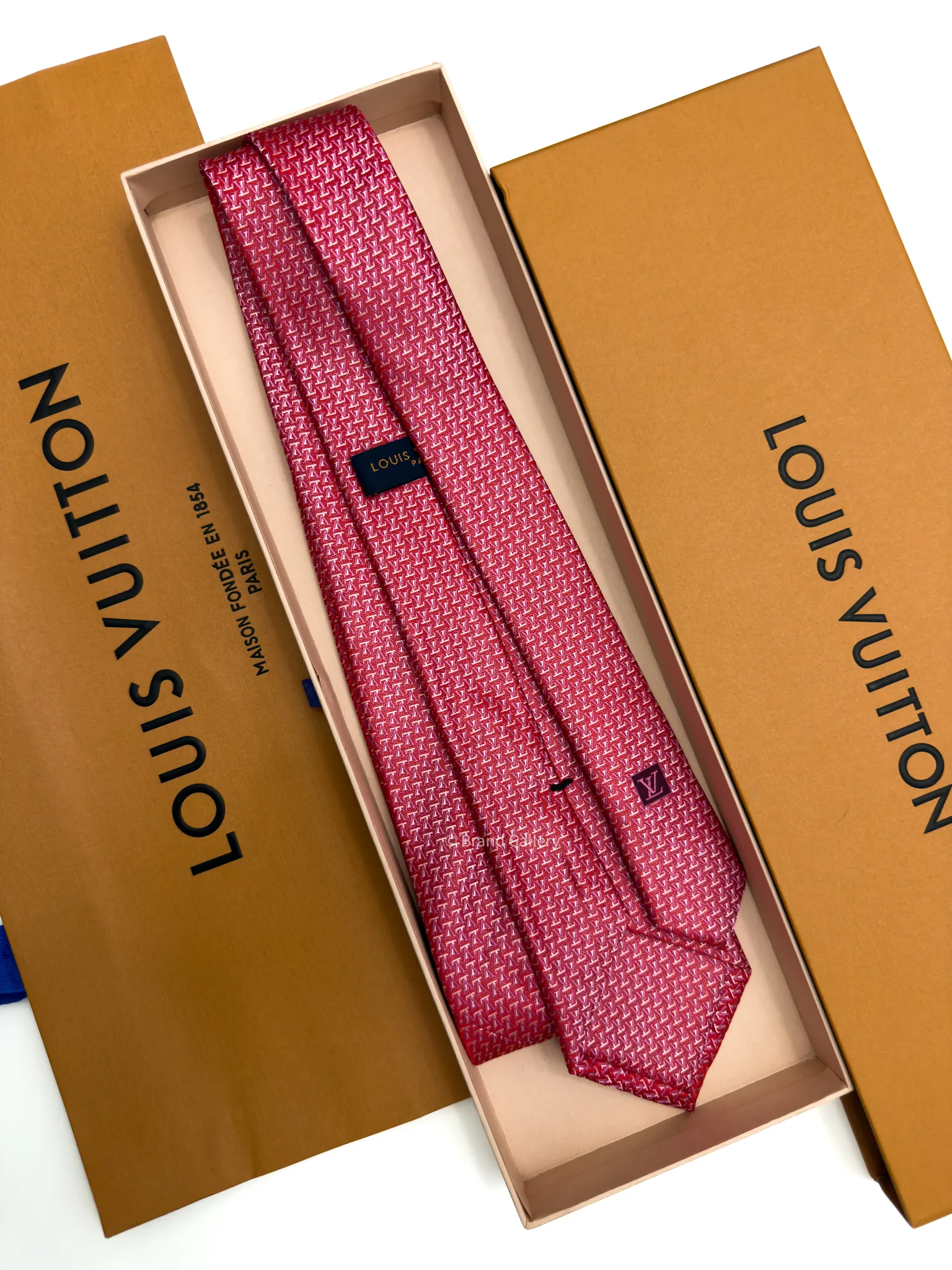 Raspberry red silk tie with repeating pink and white geometric pattern