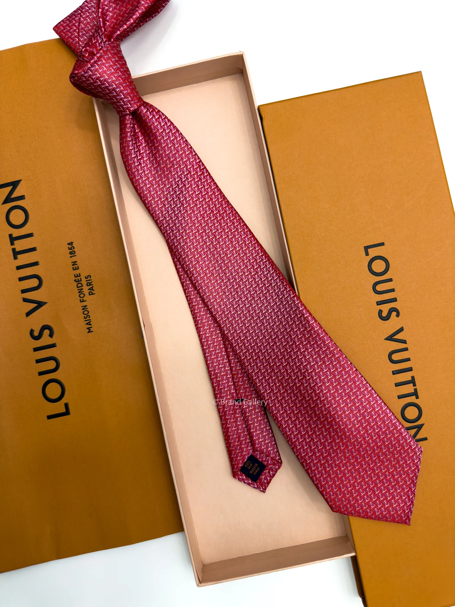 Raspberry red silk tie with repeating pink and white geometric pattern