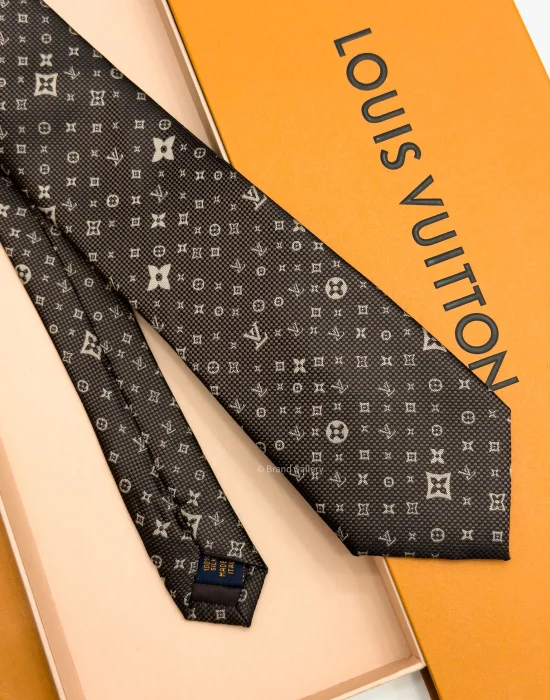 Dark brown silk tie with repeating light beige geometric pattern and textured weave
